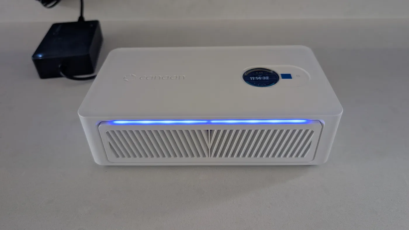 A Canaan Avalon Nano 3S running on a worktop, its round display reading 6.40 TH/s at 132 W